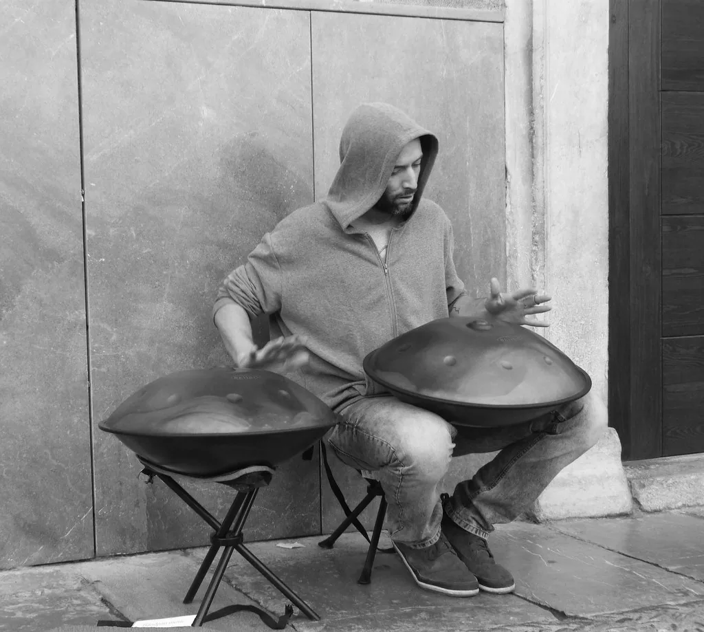 Handpan player playing two instruments on stands Handpan player playing two instruments on stands