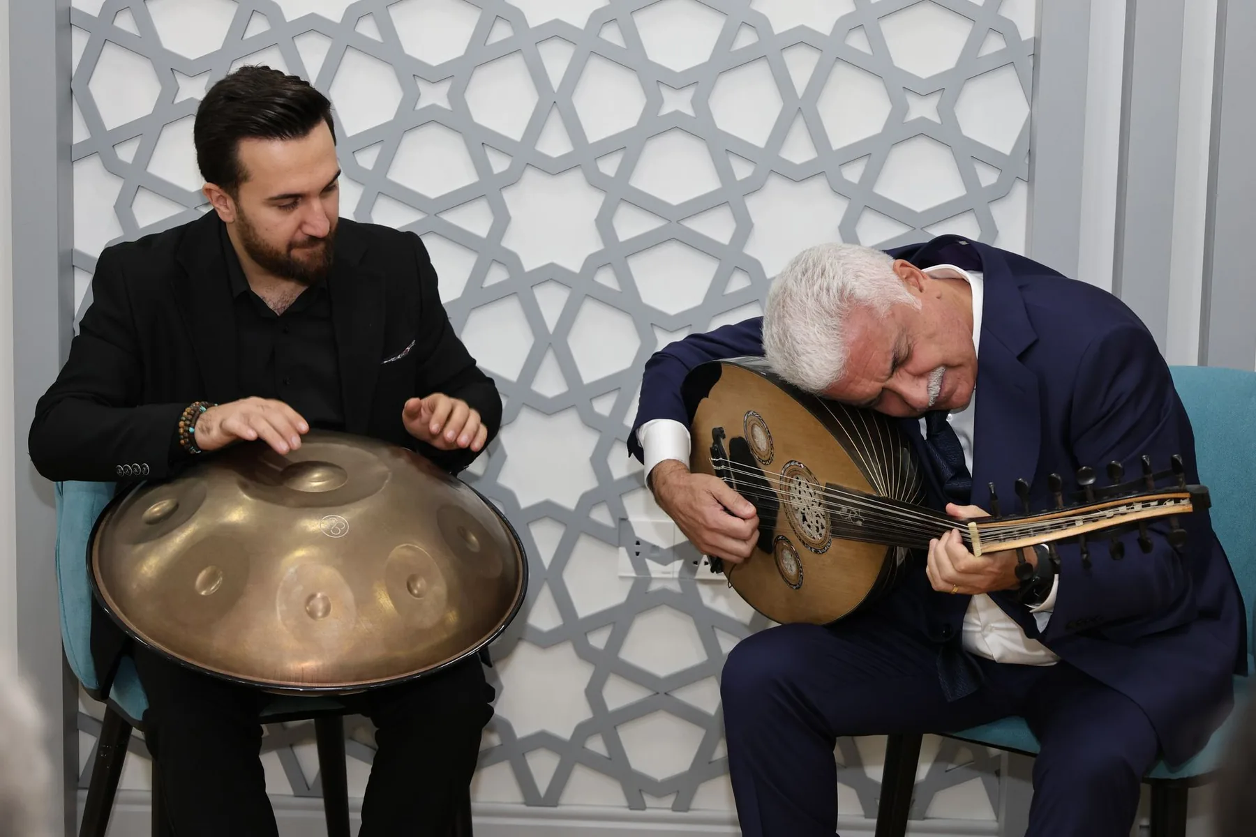 Musician playing a handpan with an oud Musician playing a handpan with an oud