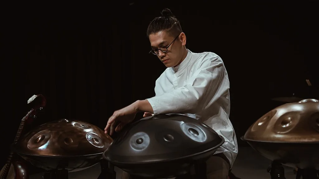 Artisan musician surrounded by several handpans