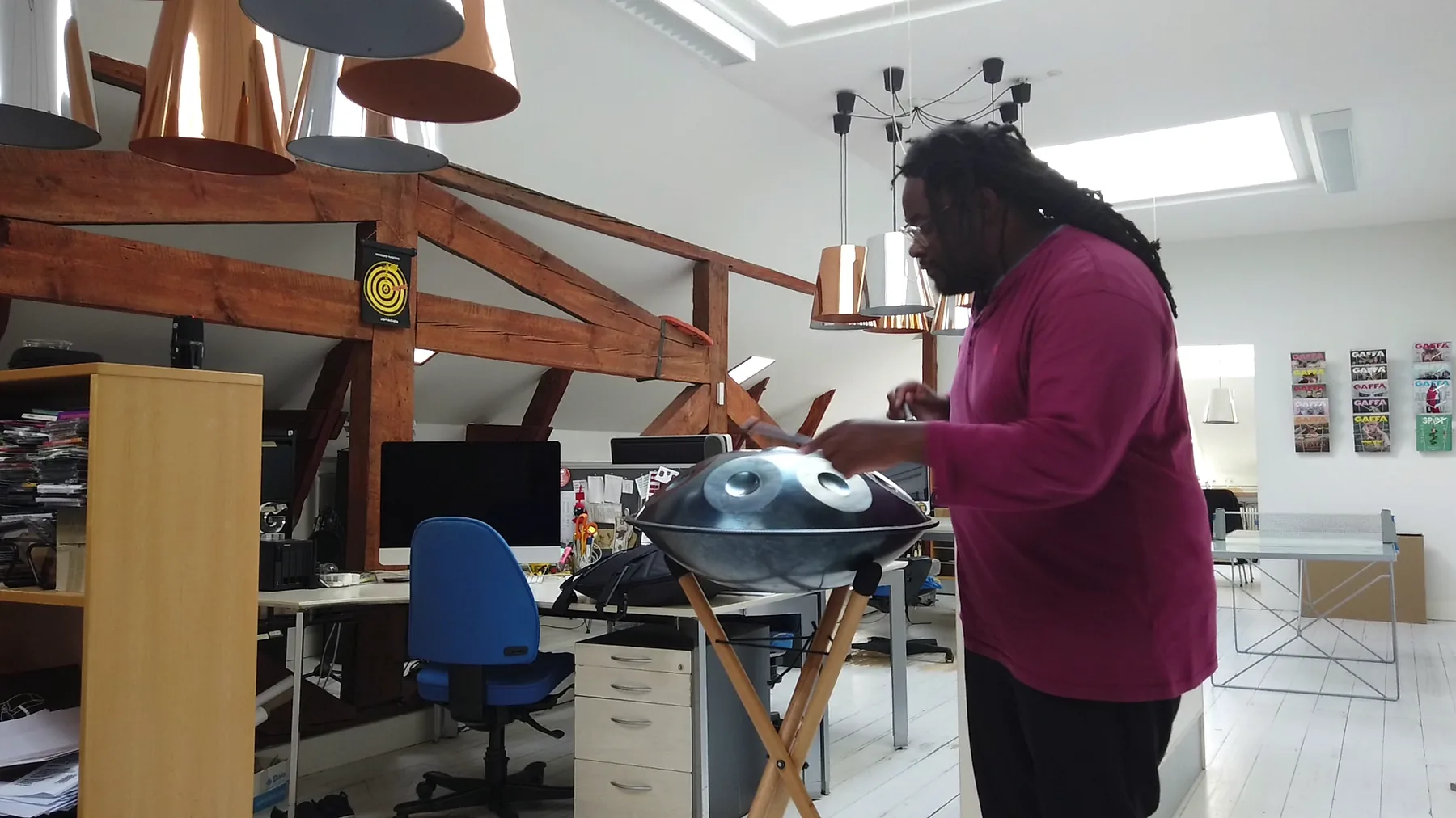 Musician playing a handpan on a stand Musician playing a handpan on a stand