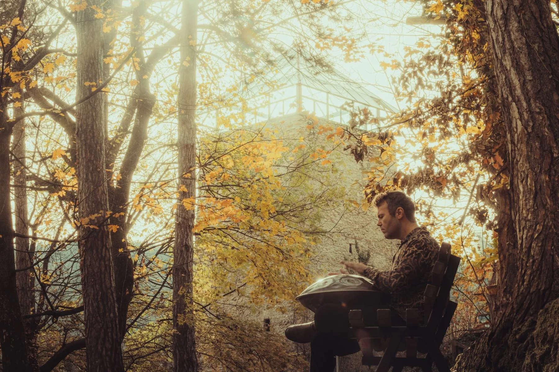 Musician playing a handpan in a forest