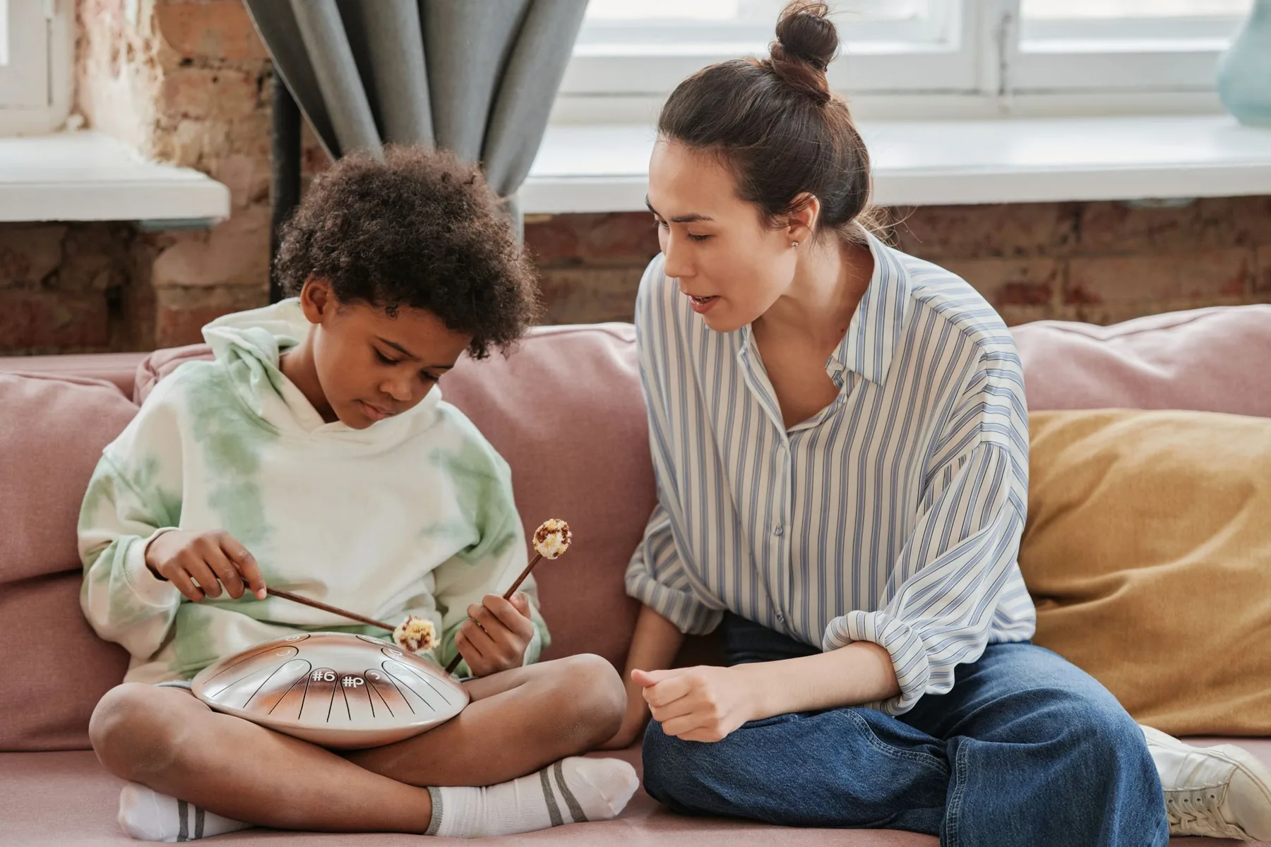 Child playing a tongue drum with accompaniment Child playing a tongue drum with accompaniment