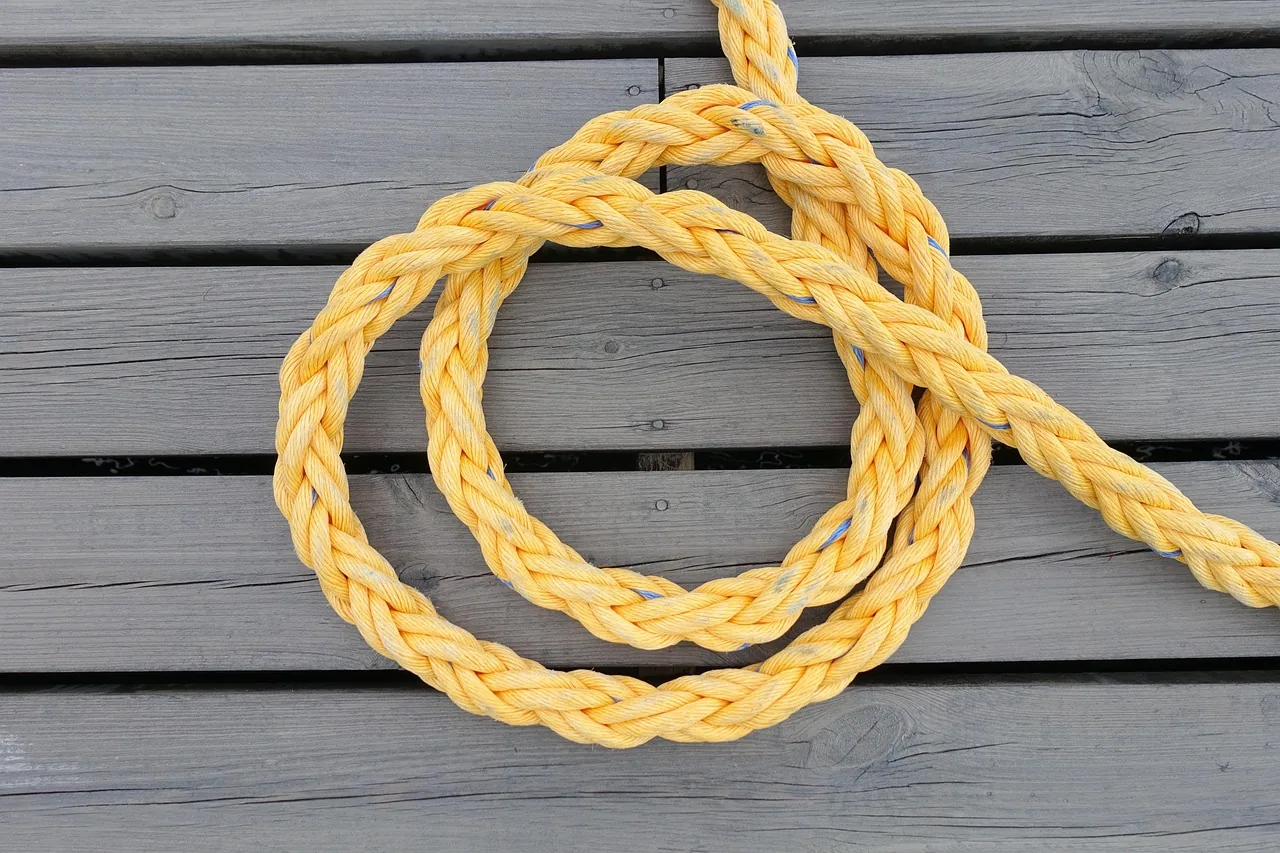 Thick yellow rope wrapped around wood Thick yellow rope wrapped around wood